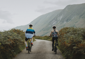couple biking down a road in scotlands hillside